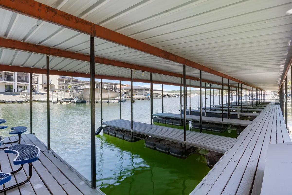A tranquil boat dock stretches out over calm lake water with a comfortable seating area. The scene is peaceful, inviting moments of relaxation or shared family outings on the water, especially during sunrise or sunset.